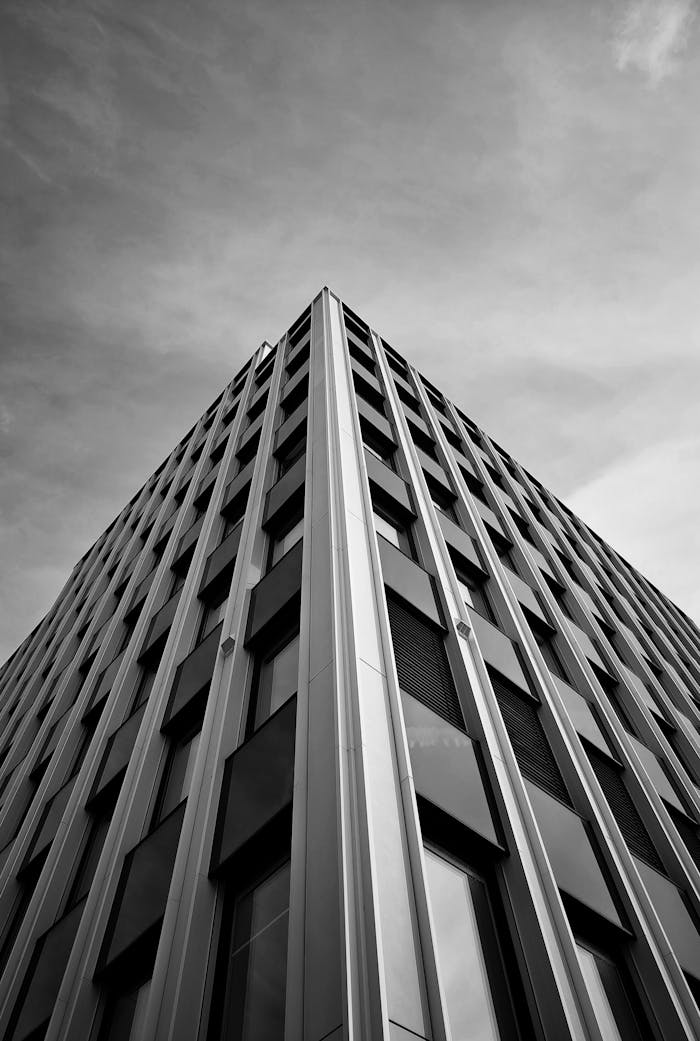 Dramatic black and white photo of a skyscraper from a low angle, highlighting modern architecture.